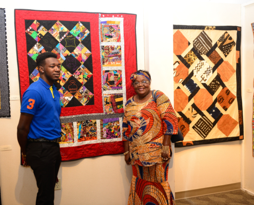 Edna C. Alston stands by her quilt in the 20 Years of Harmony: Stitches of a Quiltessential Sisterhood exhibit.